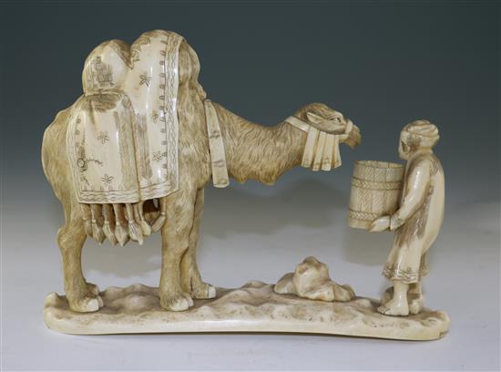 A Japanese sectional walrus ivory okimono of a Bactrian camel and a man, early 20th century, length 26cm